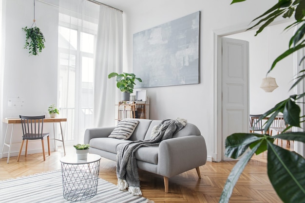 Modernes skandinavisches Wohnzimmerinterieur mit Design-Sofa, eleganter Decke, Couchtisch, Bücherständer, Pflanzen und braunem Holzparkett