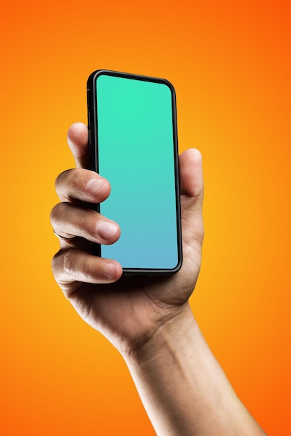 Foto modernes smartphone im schwarzen gehäuse mit einer bildschirmvorlage in der hand des mannes. isoliert auf orange farbe b