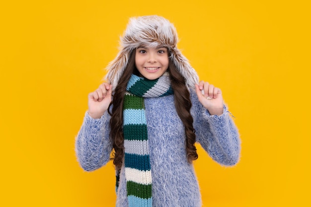 Modernes Teenager-Mädchen 12 13 14 Jahre alt mit Pullover und Strickmütze auf isoliertem gelbem Hintergrund Glückliches Gesicht positive und lächelnde Emotionen von Teenager-Mädchen