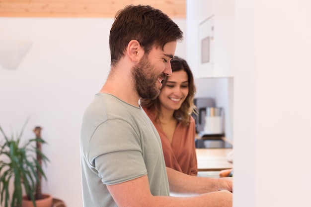 Modernes und junges Paar, das zu Hause zusammen kocht