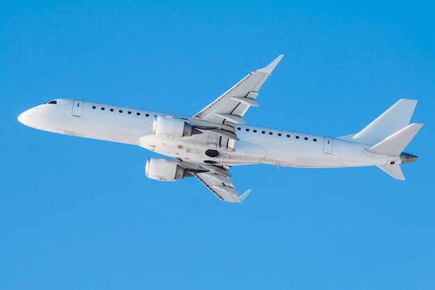 Modernes weißes Passagierflugzeug fliegt an einem klaren, sonnigen Tag gegen einen klaren blauen Himmel in die Luft