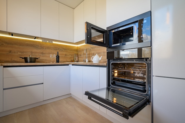 Modernes weißes und beige Holzkücheninterieur mit geöffnetem Ofen