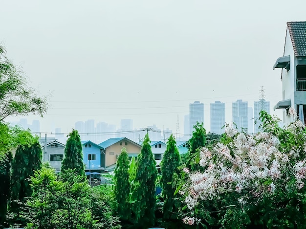 Modernes Wohnhochhaus in Bangkok, mit Blumen und Stadt im Hintergrund