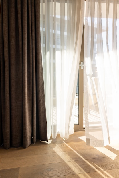 Modernes Zimmerinterieur mit offenem Fenster im minimalistischen Stil Transparenter Tüll mit Morgensonnenstrahlen