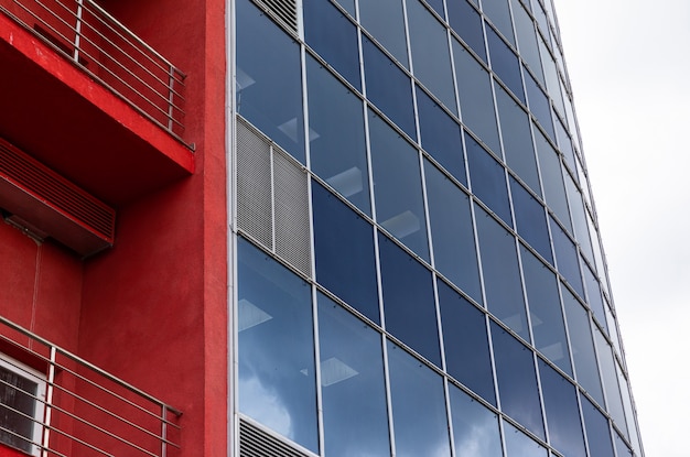 Moderno centro de negocios con fachada de vidrio y paredes de color naranja con balcón y superficie de cielo