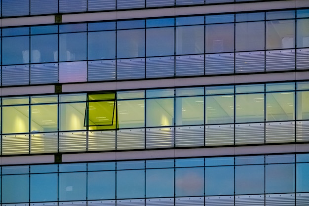 Moderno edificio de oficinas con cristales y marcos metálicos negros.