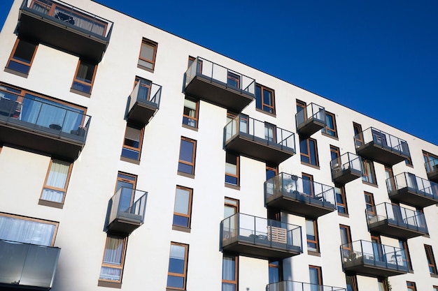 Moderno edificio residencial blanco de varios pisos con balcones