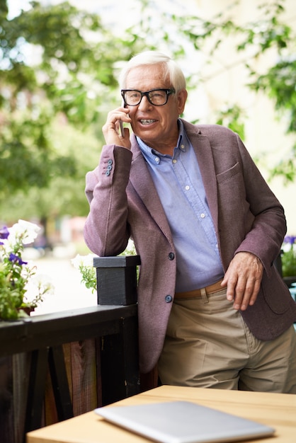 Moderno homem sênior falando por telefone