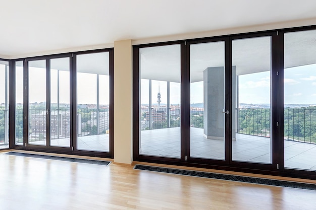 Moderno interior de loft blanco y vacío con suelo de parqué y ventanas panorámicas Con vistas a la metrópoli