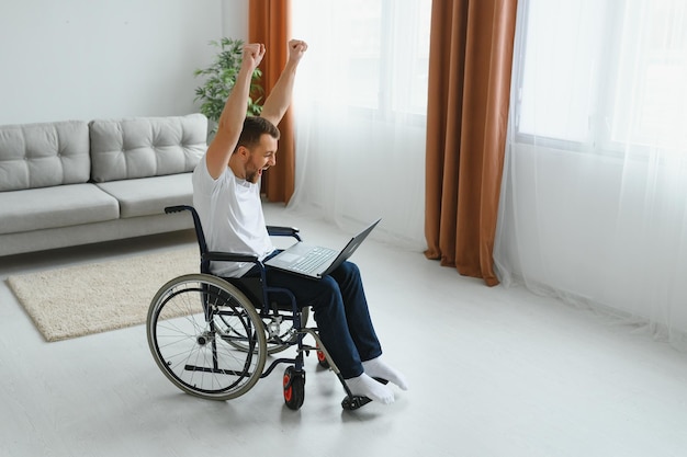 Foto moderno jovem deficiente em cadeira de rodas com videochamada