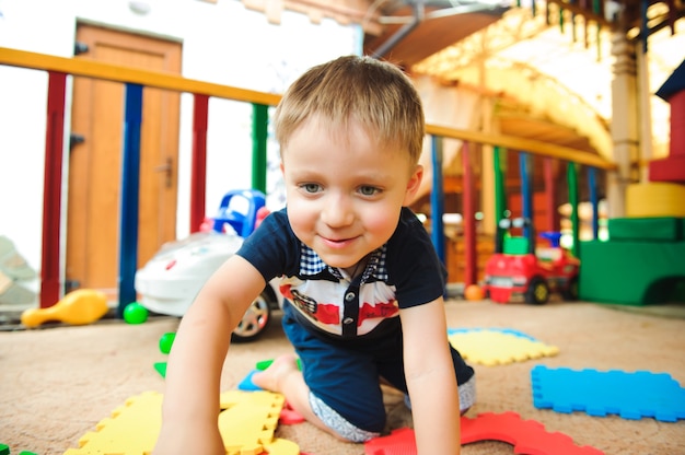 Un moderno parque infantil cubierto. Niño jugando en el patio de recreo.