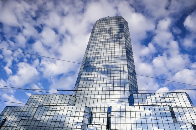 Un moderno rascacielos de oficinas reflectantes contra un cielo azul con nubes blancas varsovia polonia