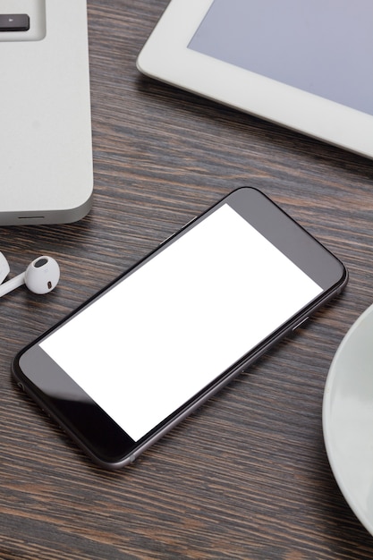 Foto moderno smartphone negro tendido en la mesa de madera de trabajo con espacio de copia en la pantalla