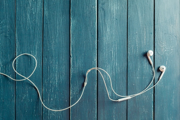 Modernos auriculares de audio portátiles en tablero de madera