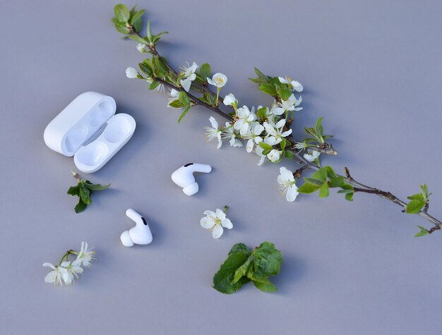 Los modernos auriculares inalámbricos suenan como flores Un concepto minimalista para escuchar música en primavera o verano