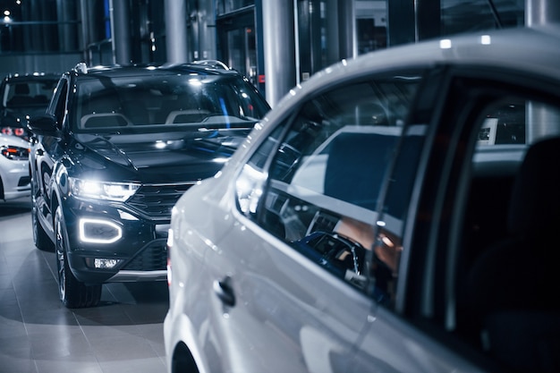 Modernos autos nuevos en blanco y negro estacionados en el autosalon.