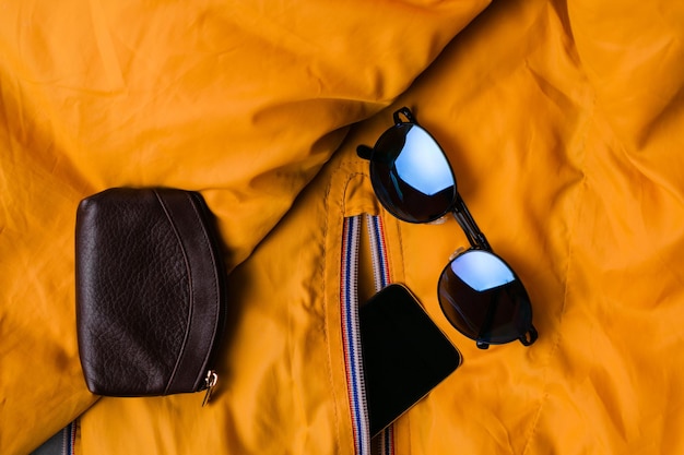 Modeset Kleidung und Accessoires mit blauer Sonnenbrille auf gelber Jacke