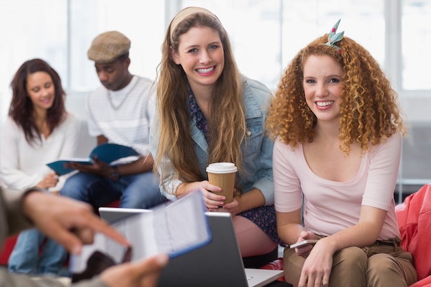 Modestudenten, die zusammen an der Kamera lächeln