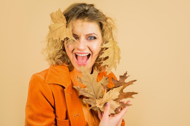 Modetrends für den Herbstlaub fallen schönes junges Mädchen mit Herbstblattherbstkleidung und -farbe