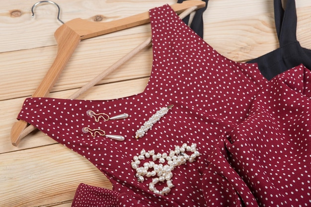 Modetrends schwarze Öko-Einkaufstasche rotes Kleid mit Tupfen auf Kleiderbügel und Perlenschmuck Haarperle