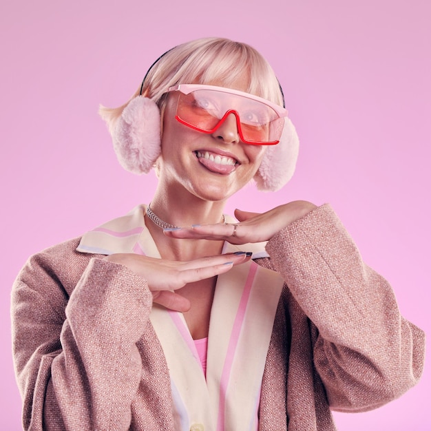 Modezunge und lustiges Gesicht einer Frau, die im Studio für Comic-Brillen auf rosa Hintergrund schrullig ist Ästhetische Modellperson mit lustigen Gedanken für ausgefallenen Vaporwave-Trend mit Kreativität und Farbe