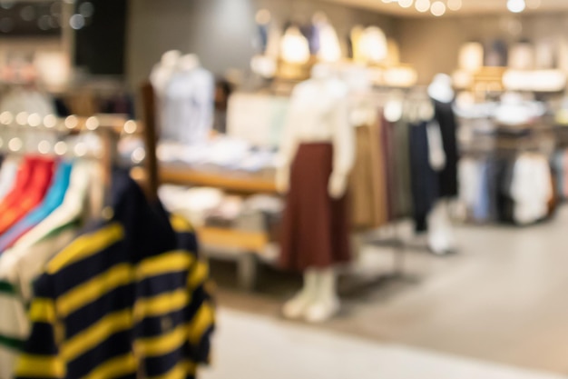 Modische Boutique-Bekleidungsgeschäftsfensteranzeige der Frau im Einkaufszentrum verwischen unscharfen Hintergrund