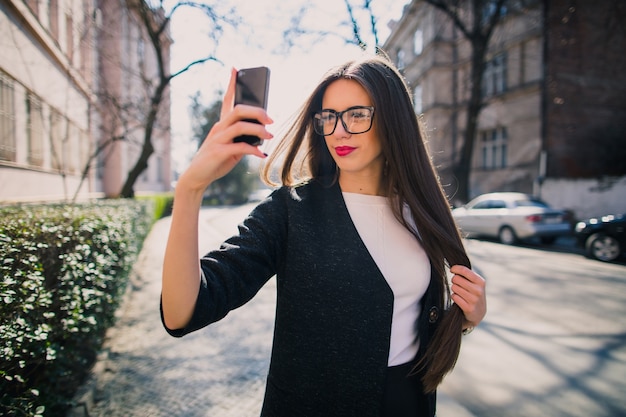 Modische Frau, die selfie auf Straße nimmt