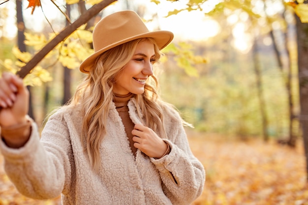 Modische Frau draußen im Herbstpark