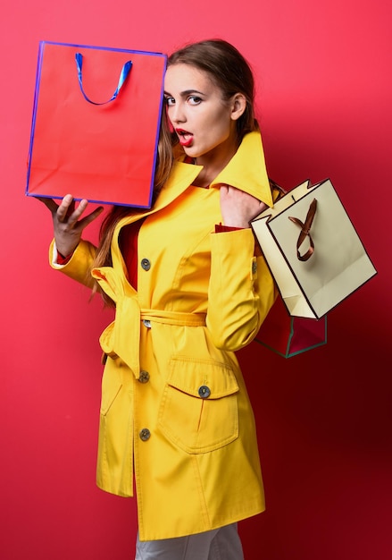 Modische Frau in stylischer Kleidung hält Einkaufstaschen am schwarzen Freitag
