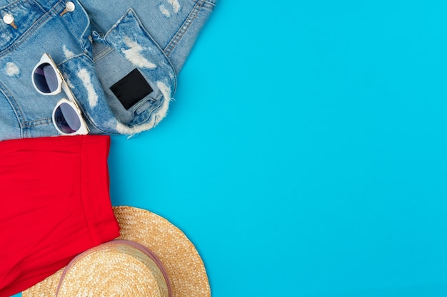 Modische Frau kleidet Flatlay auf blauem Hintergrund