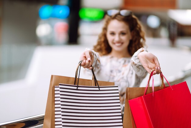 Modische Frau mit bunten Taschen im Shop-Center. Die Freude am Konsum.