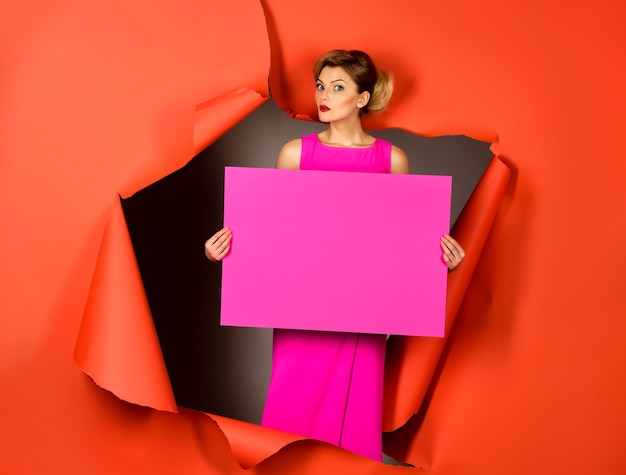 Foto modische frau mit perfekten make-up roten lippen hält leere rosa tafel für inschrift text mode