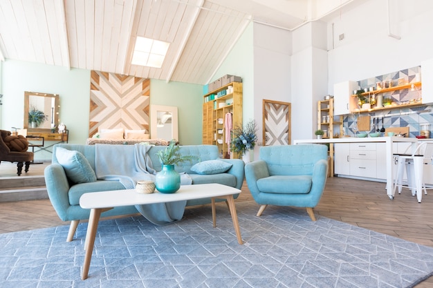 Modische, geräumige Wohnung mit stilvollem Design in den Pastellfarben Grün, Grau und Weiß mit großem Fenster und dekorativen Wänden. Schlafzimmer und Küche