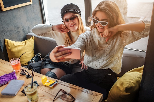 Modische junge Frauen tragen eine Sonnenbrille und machen Selfie. Models posieren. Sie sehen fantastisch aus.