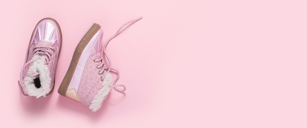 Modische Schuhe für ein Mädchen auf rosa Hintergrund. Ansicht von oben, flach. Banner.