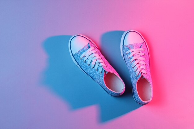 Modische Turnschuhe neonrosa blaues Licht.