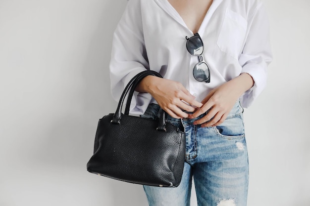 Modische und lässige Frau mit Sonnenbrille mit schwarzer Handtasche Kopierraum für Mode