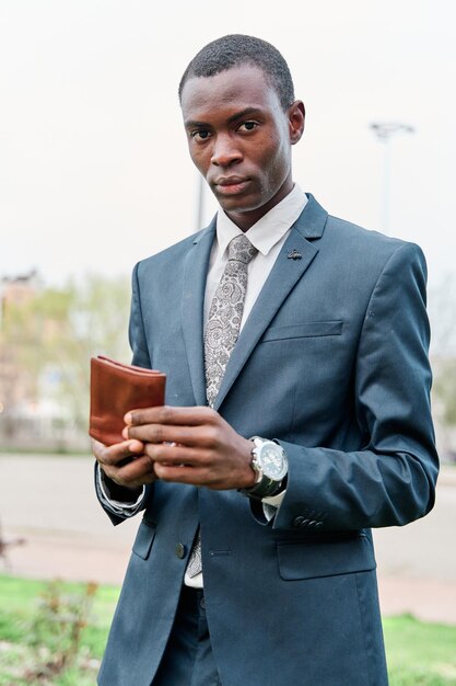 Modischer Herr mit Brieftasche und Blick in die Kamera