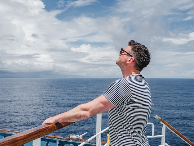 Modischer Mann auf dem leeren Deck eines Kreuzfahrtschiffes