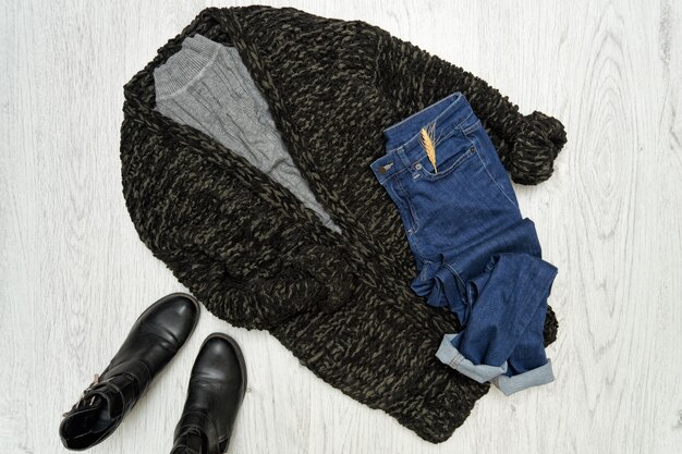 Modisches Konzept. Schwarze Strickjacke, Schuhe und Blue Jeans