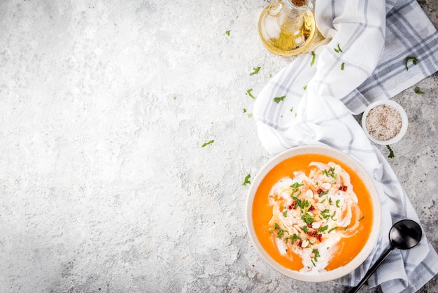 Modisches Lebensmittel des strengen Vegetariers, Süßkartoffel-Detox-Suppe mit Kokosmilch, getrockneten Tomaten, Erdnüssen und Kräutern, auf Draufsicht des grauen Steintabellenkopien-Raumes