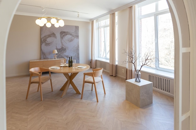 Modisches, modernes Design-Luxusapartment in hellen Farben, heller Tag hinter riesigen Fenstern, stilvolle Dekoration und niemand drinnen