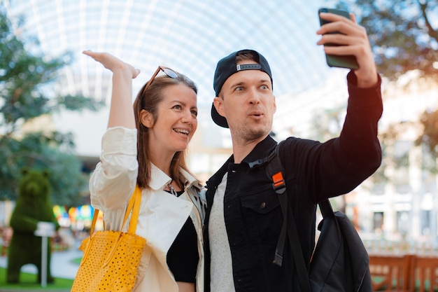 Modisches Paar, das Selfie mit dem Handy macht. Mann und Frau mit Sonnenbrille treffen Freunde in der Stadt Datumsfoto auf einem Smartphone