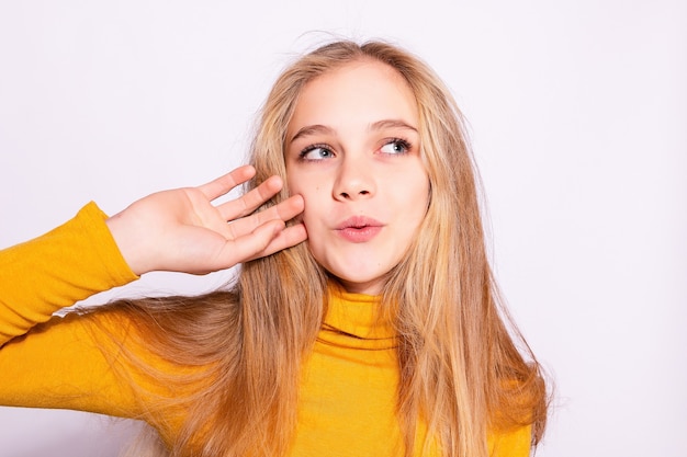 Modisches schönes Hippie-Mädchen. Foto der positiven jungen netten Frau im gelben Kniestrumpf mit weißem Hintergrund.