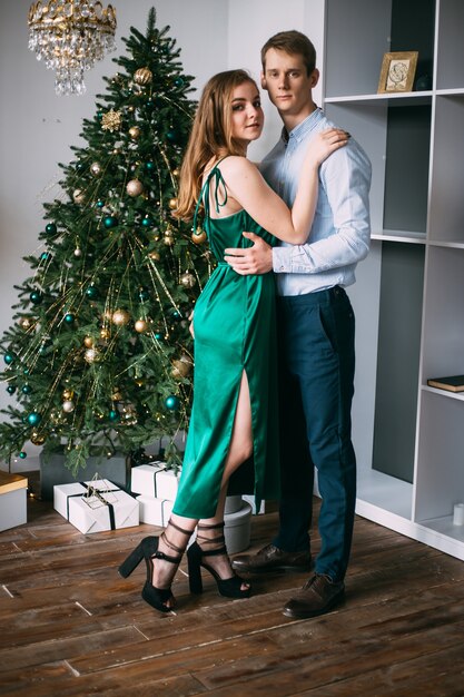 Modisches stilvolles Paar nahe einem Weihnachtsbaum zu Hause.