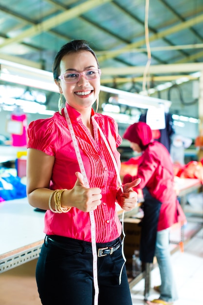 Foto modista asiática en una fábrica textil