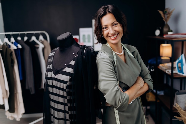Modista cerca de maniquí de sastrería
