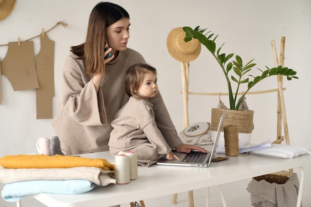 Modista haciendo ropa en su estudio con su hija