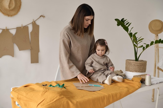 Modista haciendo ropa en su estudio con su hija