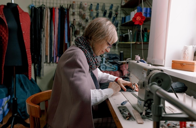 Una modista utiliza una máquina de coser para crear ropa a medida en un taller.